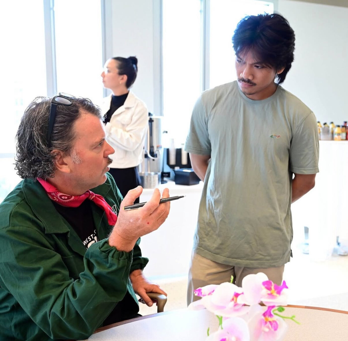 Chris Schultz in conversation with a younger founder, pen in hand